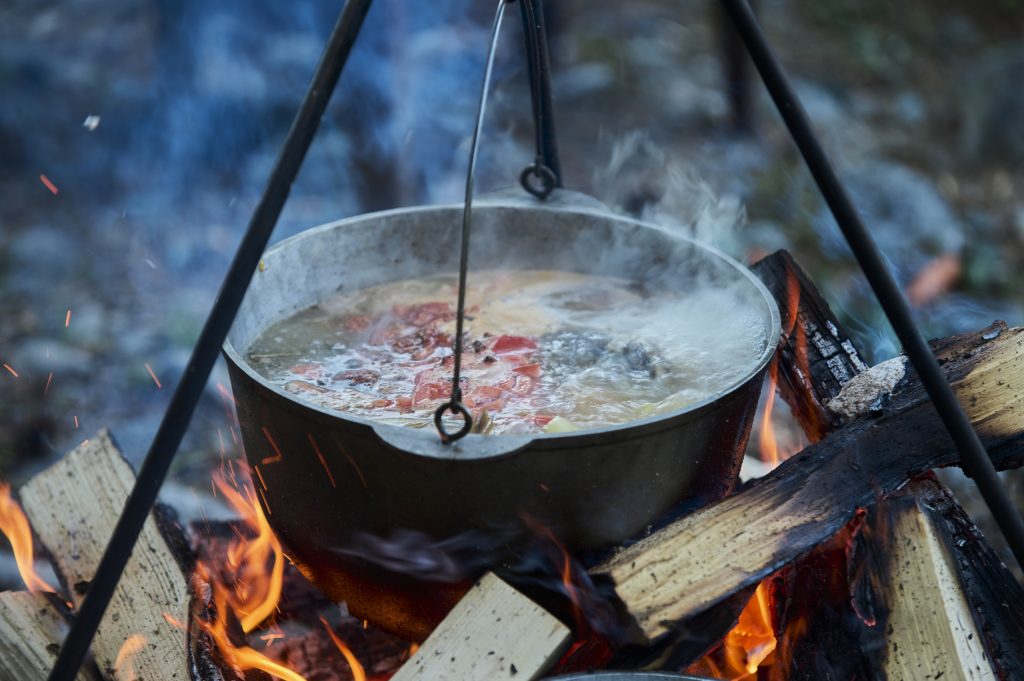 Cooking fish soup in the stowed bowler over a campfire.